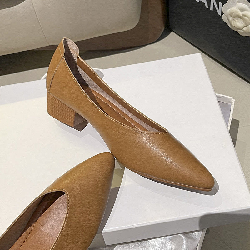 Beige spidssnudet pumps med blokhæl holdt i hånden, viser sideprofil og hældetalje — Venzelo