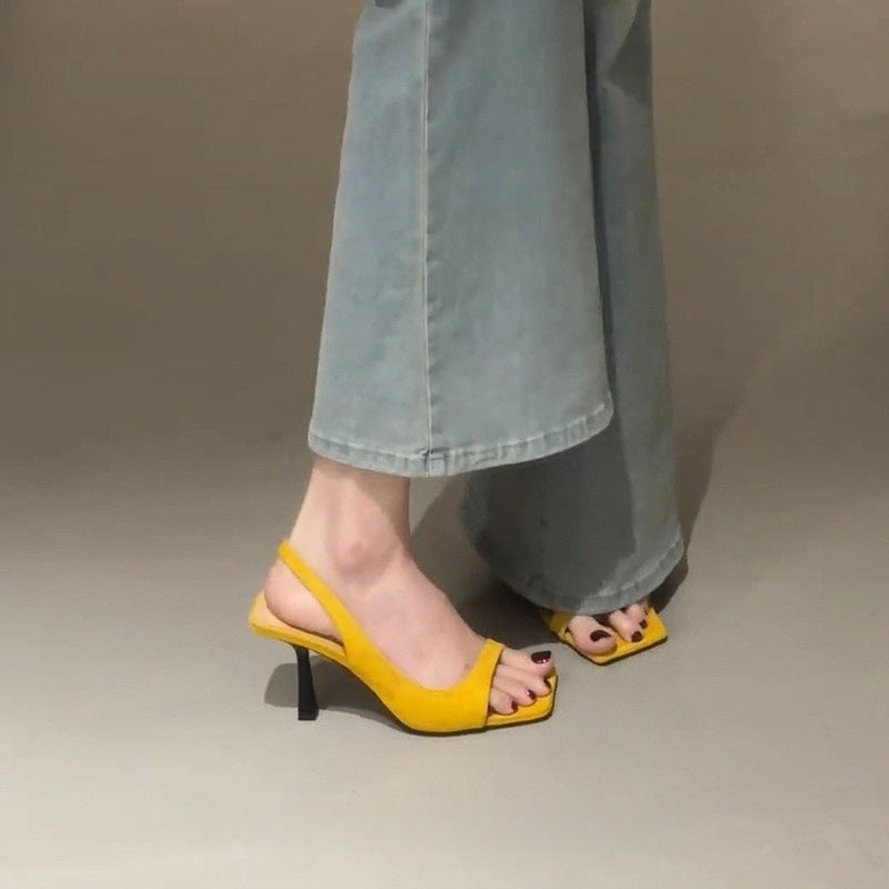 Gul slingback sandal med firkantet tå og slingback-rem set fra siden på model med jeans — Venzelo