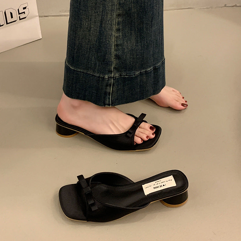 Sort sløjfe mule med firkantet tå og lav blokhæl på model med jeans — Venzelo