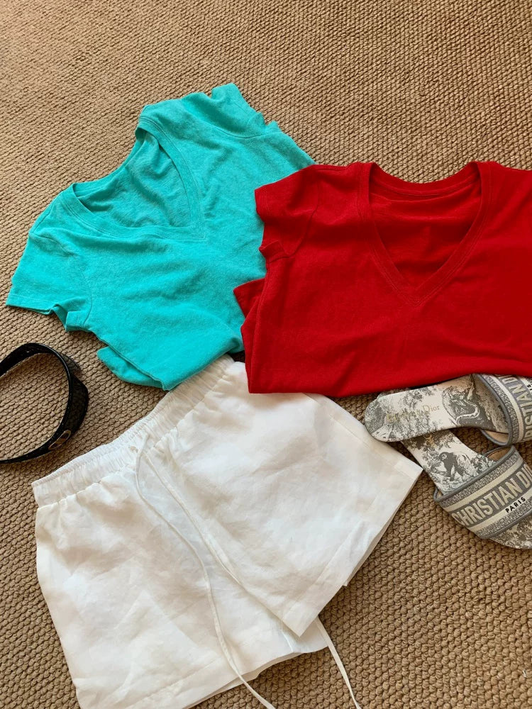 Turkis og rød V-udskæring t-shirt lagt ud på gulv i begge farver — Venzelo
