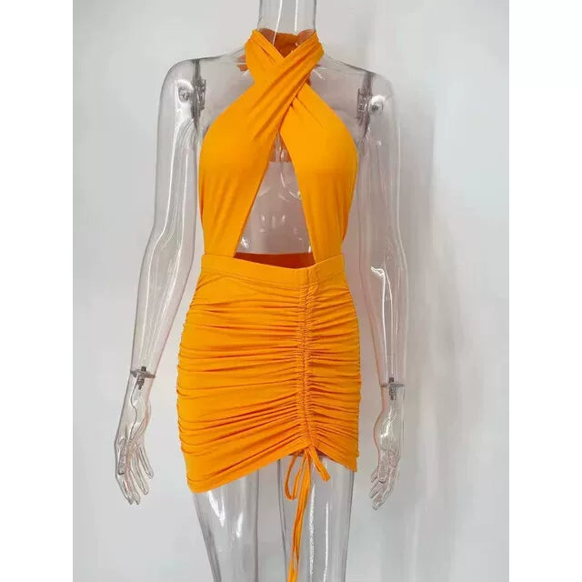 Orange minikjole med krydshalter og rynket nederdel på mannequin — Venzelo