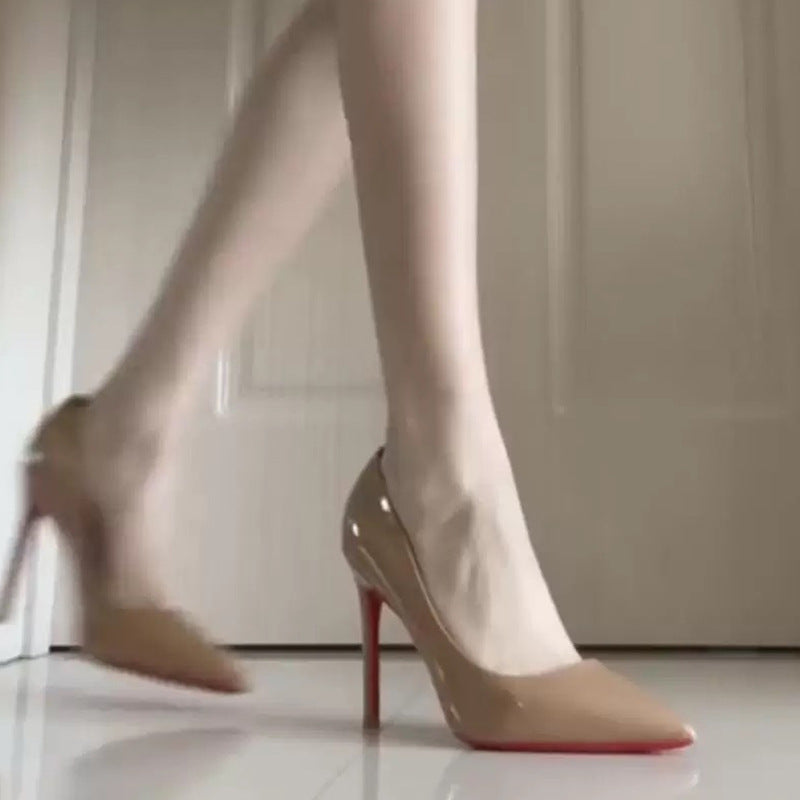 Nude lakeret stilethæl-pumps med rød sål og spids tå på model i bevægelse — Venzelo