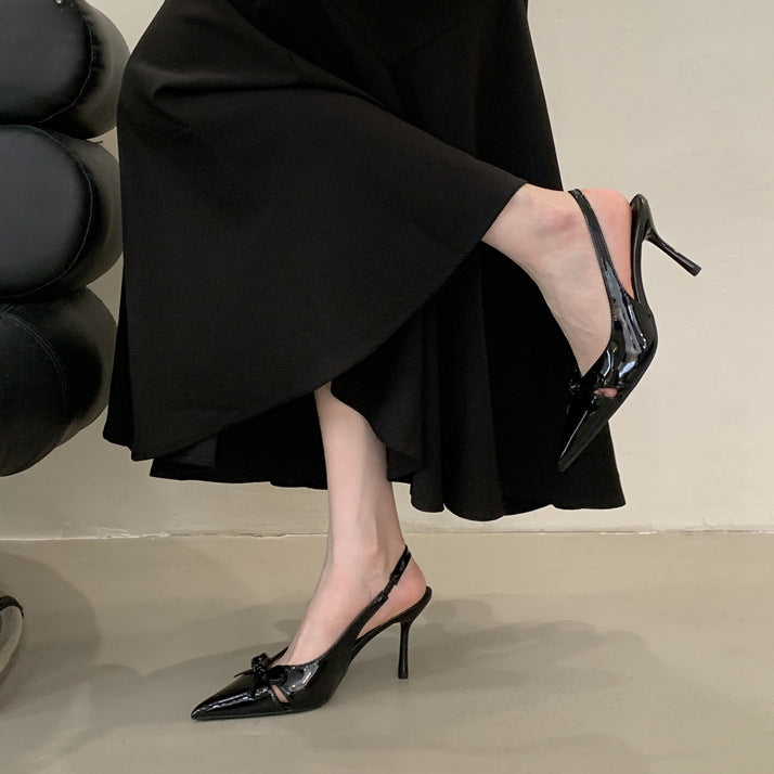 Sort slingback stilethæl med sløjfe og spidsfront set fra siden på model i sort kjole — Venzelo
