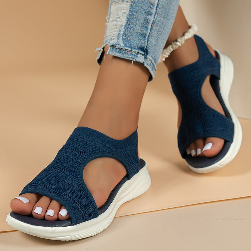 Marineblå strikket sandal med hvid sål og elastisk hælstrop set fra siden — Venzelo