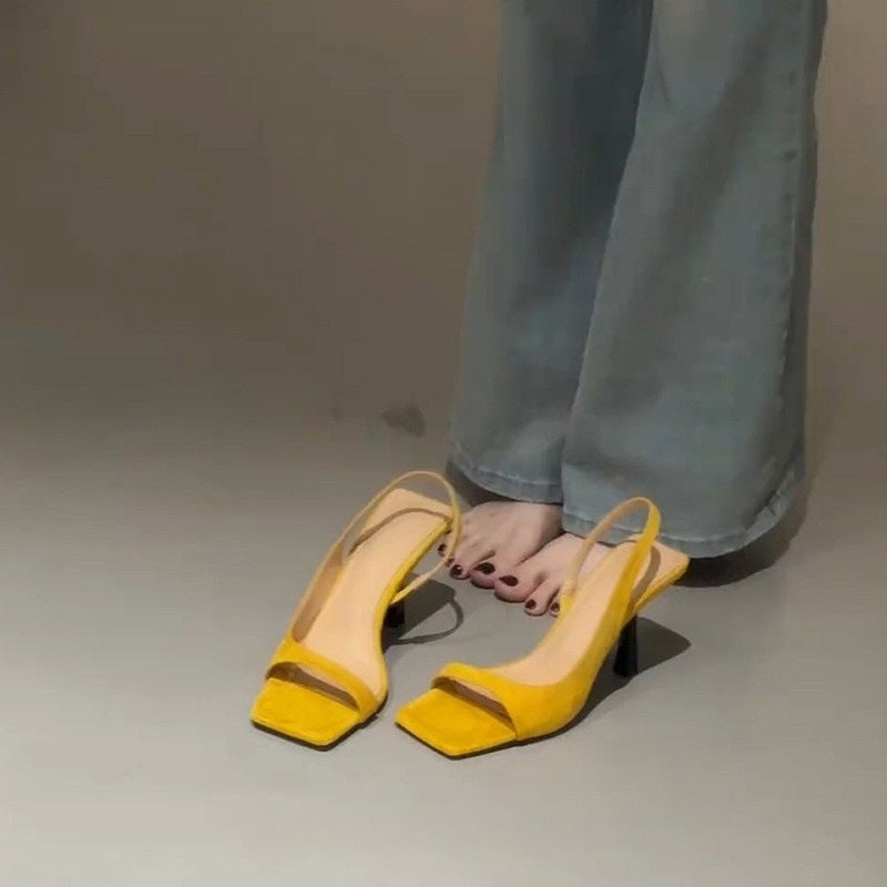 Gul slingback sandal med firkantet tå sat ved siden af model på gulvet set oppefra — Venzelo