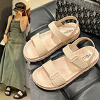 Beige sandal vist på model iført denimkjole samt nærbillede af sandal på sort lædersæde — Venzelo