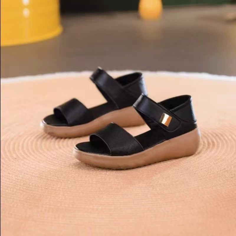 Sort sandal med bred rem og guldfarvet metaldetalje set fra siden — Venzelo