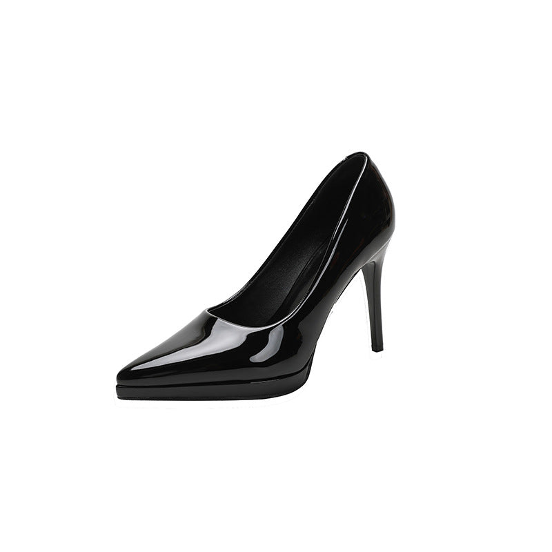 Sort lakeret stiletpumps med spids tå og diskret platform på hvid baggrund — Venzelo