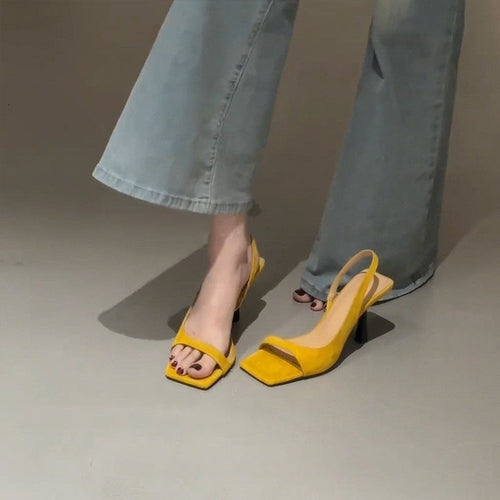 Gul slingback sandal med firkantet tå og stilethæl set forfra på model med jeans — Venzelo