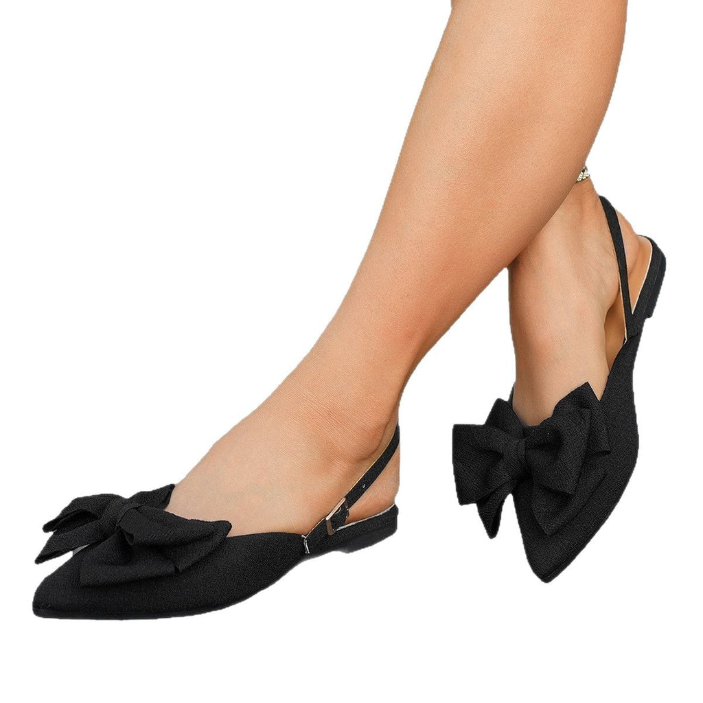 Sort slingback fladsko med sløjfe på model set fra siden mod hvid baggrund — Venzelo
